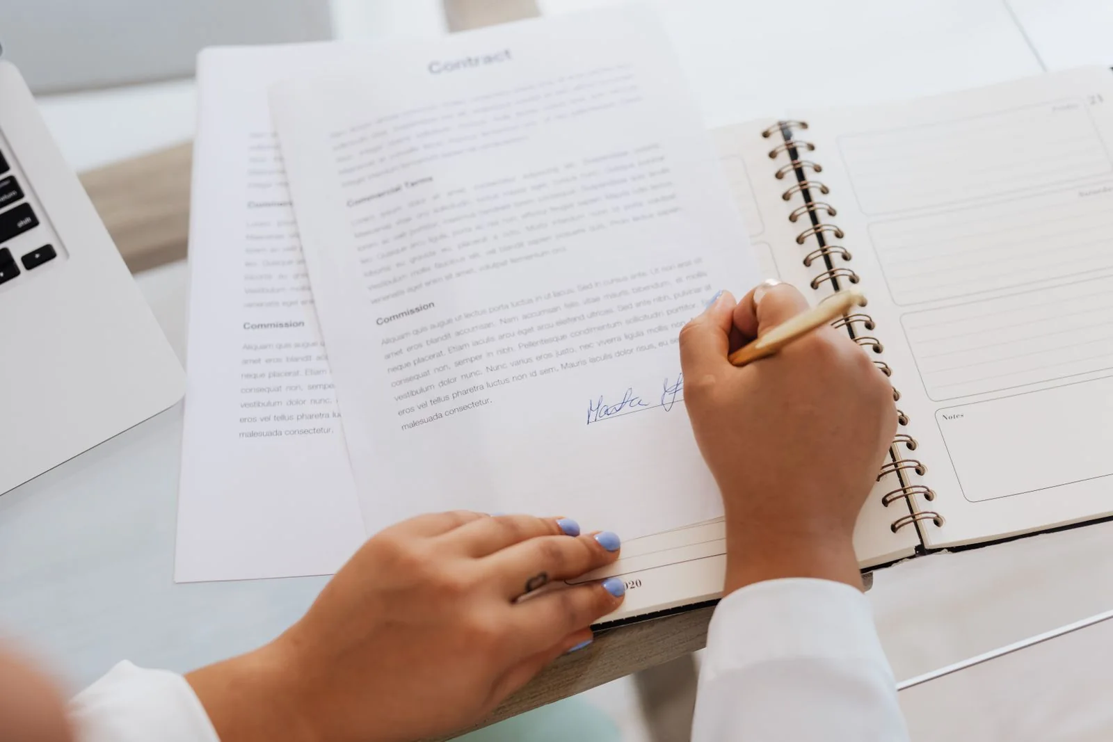 Pessoa assinando um contrato durante uma análise de condições
